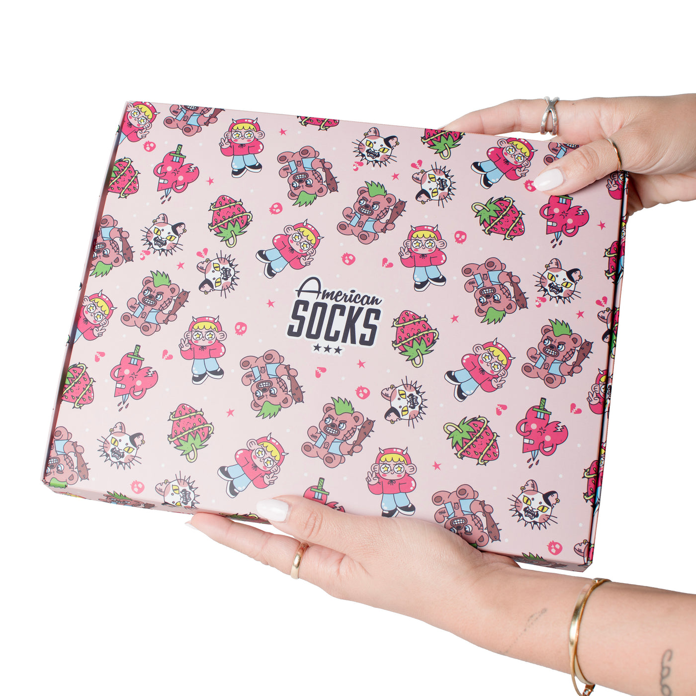 Hands holding up cute sweet madness giftbox with illustration of chaotic characters by american socks