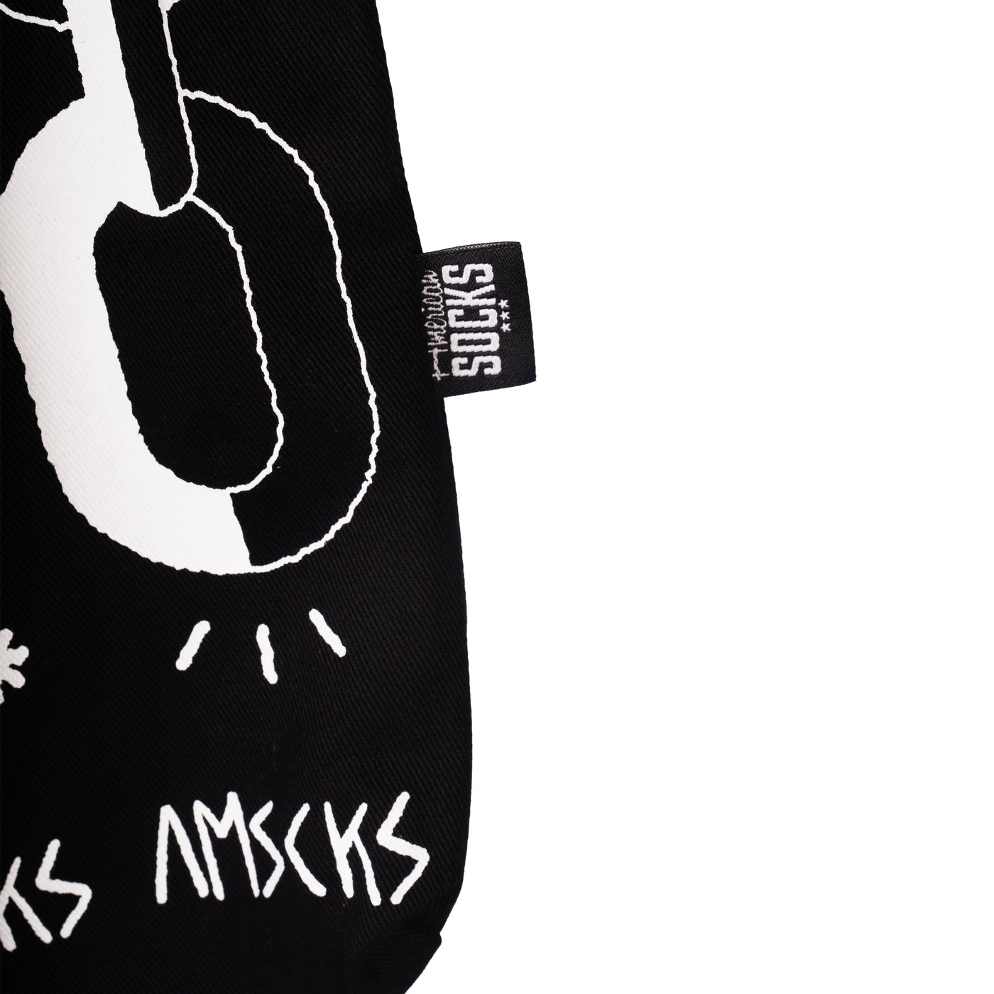 Close-up of american socks tag on the side of a black tote bag on a white background